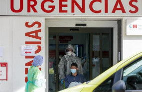 ep un sanitario empuja una silla de ruedas con un enfermo leve de covid-19 para su posterior