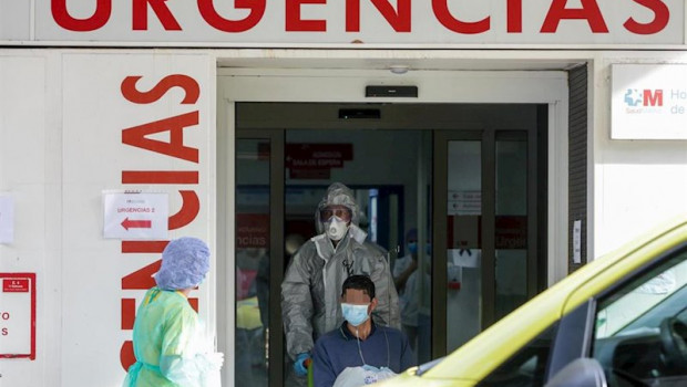 ep un sanitario empuja una silla de ruedas con un enfermo leve de covid-19 para su posterior
