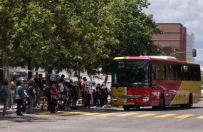 ep una fila de pasajeros espera para subirse a un autobus