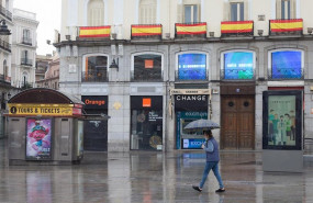 ep una mujer protegida con mascarilla camina por la centrica puerta del sol practicamente vacia