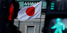 le drapeau national japonais hisse au sommet du siege de la banque du japon est vu entre les feux de signalisation a tokyo 