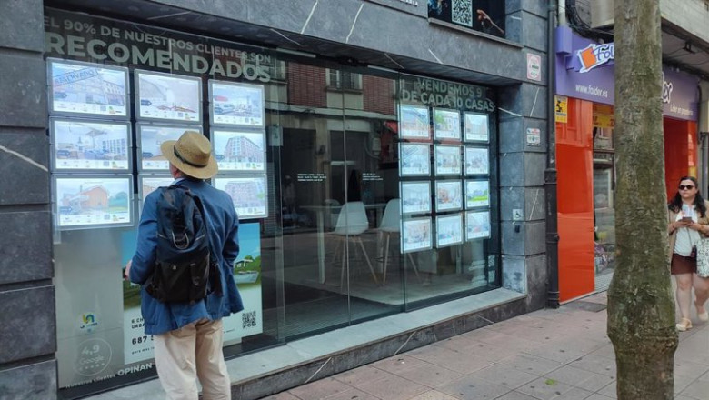 ep archivo   un hombre mira anuncios de una agencia inmobiliaria en oviedo