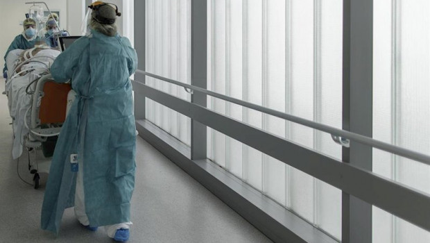 ep personal sanitario totalmente protegido trasladan a un paciente ingresado en la unidad de