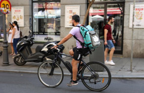 ep fotografia de un repartidor de la empresa de reparto deliveroo transitando en bicliceta por una