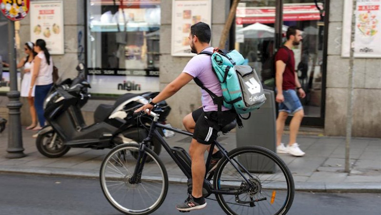 ep fotografia de un repartidor de la empresa de reparto deliveroo transitando en bicliceta por una
