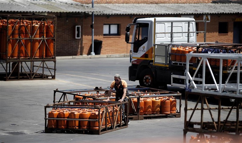 ep un hombre apila bombonas de butano en un almacen
