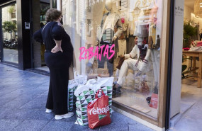 ep una senora observa un escaparate como muchas bolsas de compras en el suelo
