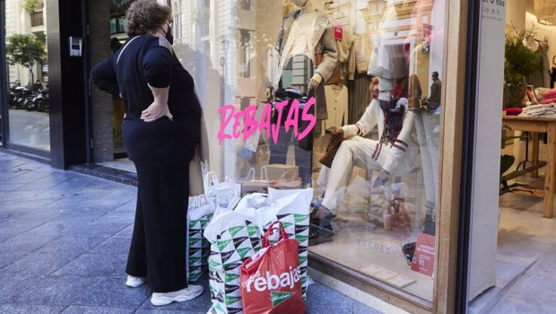 ep una senora observa un escaparate como muchas bolsas de compras en el suelo