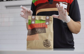 ep una empleada protegida con pantalla mascarilla y guantes prepara un pedido en un establecimiento