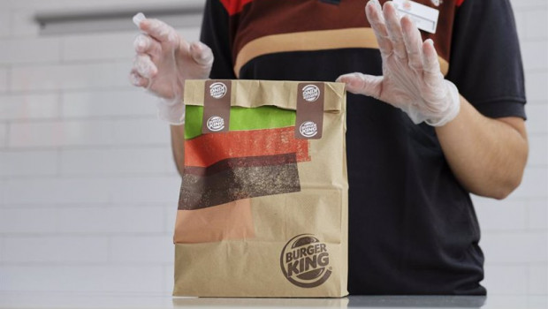 ep una empleada protegida con pantalla mascarilla y guantes prepara un pedido en un establecimiento