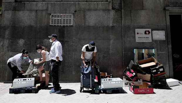 ep dos personas recogen alimentos izquierda y derecha que les dan dos voluntarios a las puertas de