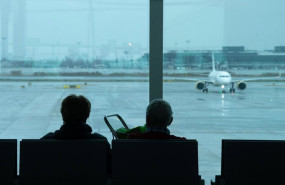 ep archivo   archivo   dos personas esperan sentadas frente a un avion aparcado en la pista del