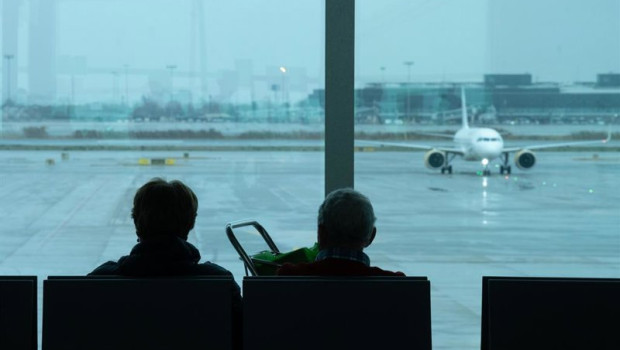 ep archivo   archivo   dos personas esperan sentadas frente a un avion aparcado en la pista del