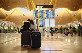 ep archivo   dos viajeros senalando un panel de vuelo en la terminal t4 del aeropuerto adolfo suarez