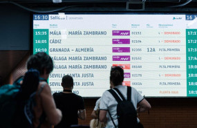 ep archivo   varias personas observan una pantalla informativa en la estacion de madrid   puerta de