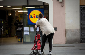 ep una mujer espera con su carro de la compra a poder entrar a un supermercado lidl tras las medidas