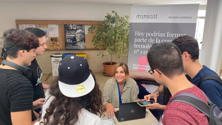 ep una empleada de minsait explica a un grupo de jovenes las bondades de la compania en un evento ep una empleada de minsait explica a un grupo de jovenes las bondades de la compania en un evento