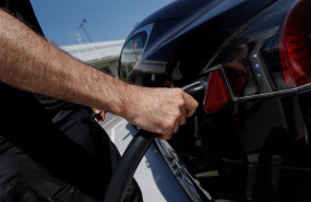 ep una persona recarga un coche electrico en un punto de recarga
