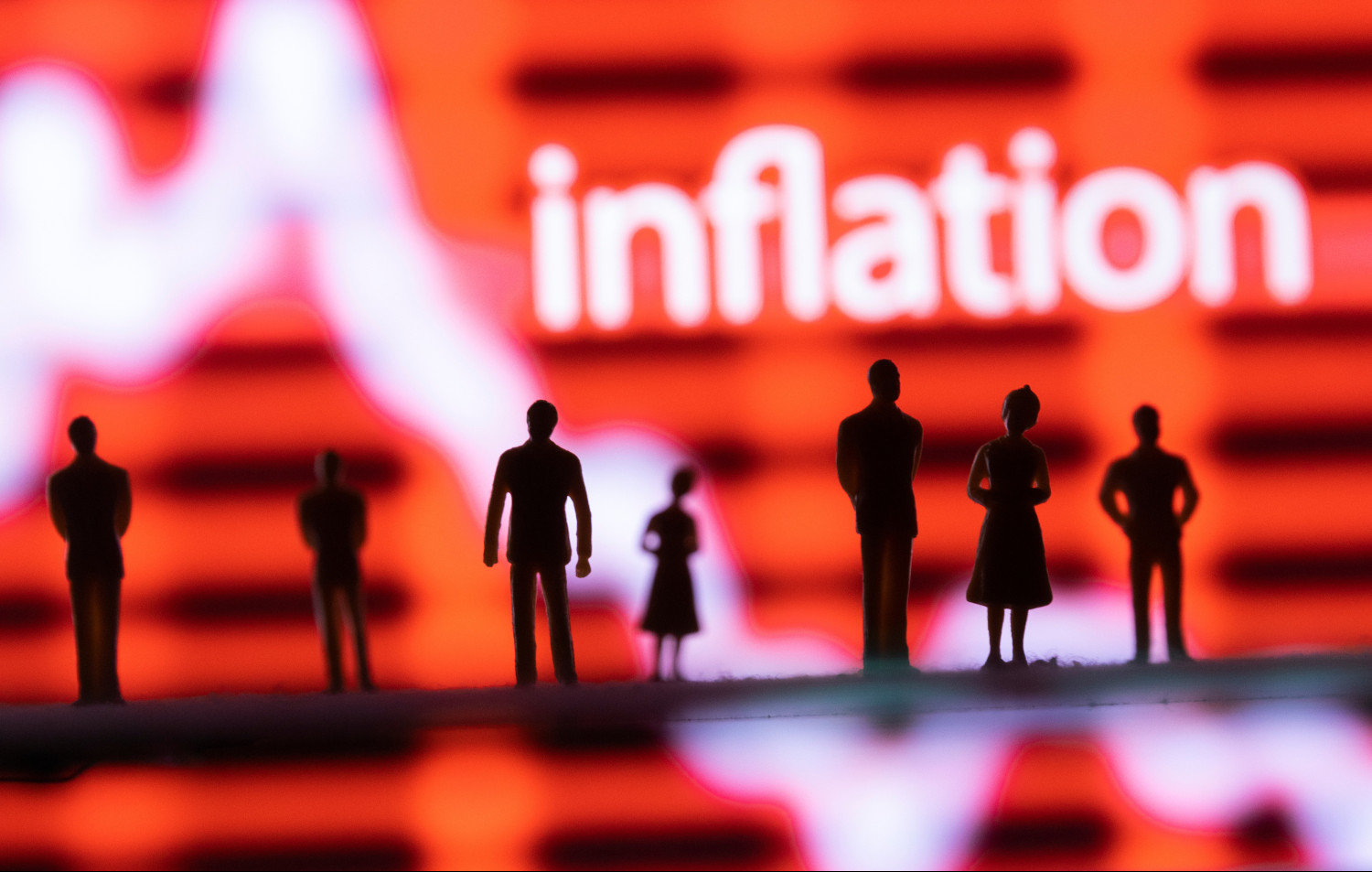 illustration montrant des figurines un graphique boursier et le mot inflation 