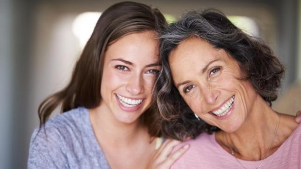 ep a laughing mother and daughter standing in their home and looking at the camera