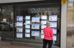 ep archivo   una mujer echa un vistazo a las ofertas de una agencia inmobiliaria