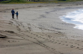 ep una mujer con un nino en la playa de la malagueta el primer dia en el que los menores de 14 anos