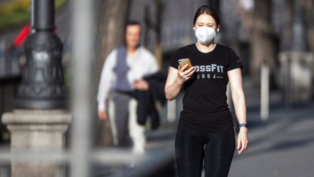 ep una mujer con mascarilla utilizando el telefono movil