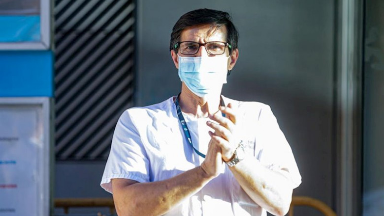 ep un sanitario del hospital general universitario gregorio maranon y un transeunte aplauden a las ep un sanitario del hospital general universitario gregorio maranon y un transeunte aplauden a las