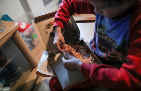 ep un nino come un trozo de pizza del menu infantil de telepizza mientras ve la television en su