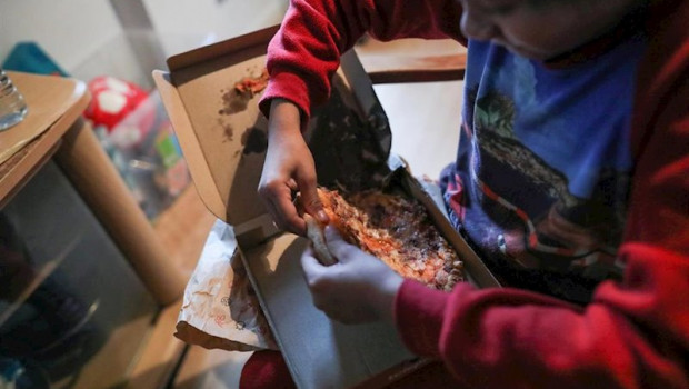 ep un nino come un trozo de pizza del menu infantil de telepizza mientras ve la television en su