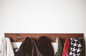 1618925118 wooden coat hanger full of coats on white wall min 