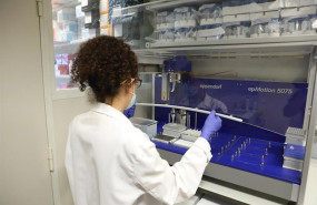 ep una biologa trabaja con un robot pipeteador para cargar placas de pcr