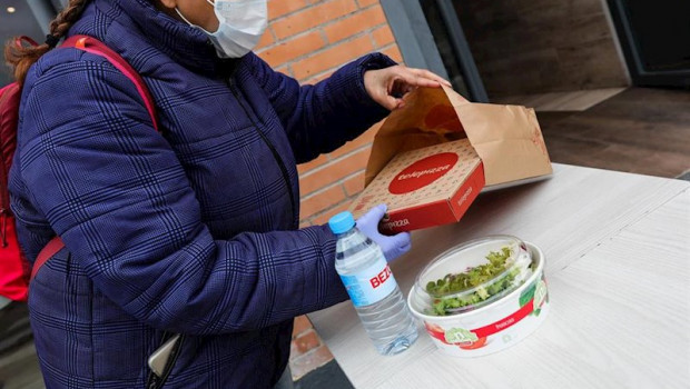 ep una mujer protegida con mascarilla y guantes de latex abre el menu infantil de telepizza en el