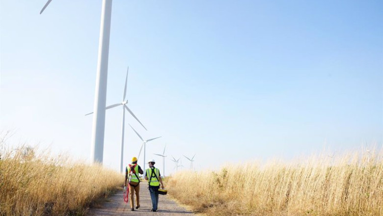ep archivo wide perspective of wind turbine engineers walking with coworker in wind farms ep archivo wide perspective of wind turbine engineers walking with coworker in wind farms