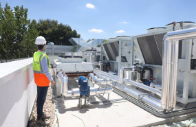 ep archivo - un trabajador camina por el tejado de la piscina cubierta del centro deportivo