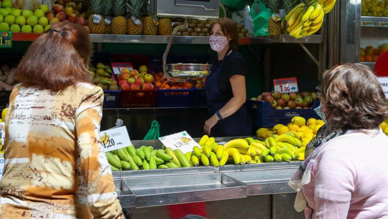 ep archivo   una trabajadora de una fruteria del mercado central de valencia atiende a dos clientas