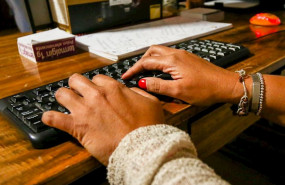 ep unas manos de mujer escriben en el teclado de un ordenador sobre una mesa de madera