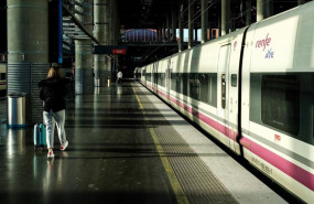 ep foto de archivo una mujer camina por el anden junto a un tren de ave de renfe estacionado en las