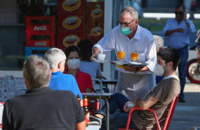 ep un camarero sirve a los clientes en una terraza de un bar