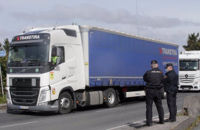 ep dos agentes de policia nacional observan los camiones parados en el arcen en uno de los accesos
