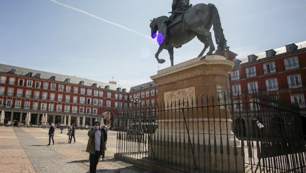 ep un hombre con mascarilla pasea cerca de la estatua equestre de felipe iii en la plaza mayor de