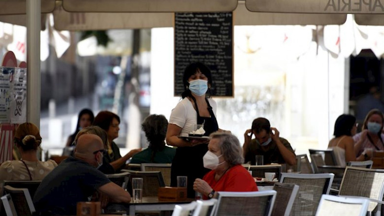 Una camarera con mascarilla atiende a los clientes en una terraza de un bar | Óscar Cañas - Europa Press ep una camarera con mascarilla atiende a los clientes en una terraza de un bar