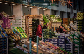 ep dos hombres junto a un puesto de frutas