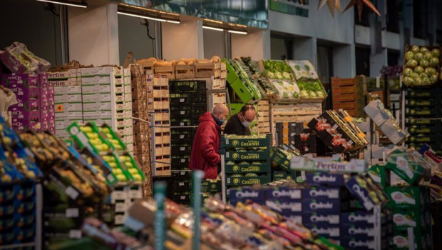 ep dos hombres junto a un puesto de frutas