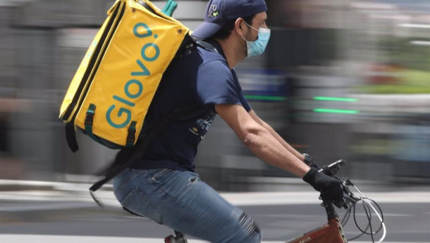 ep un repartidor de glovo monta una bicicleta durante su jornada laboral