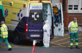 ep varios sanitarios protegidos uno con un traje y otro con mascarilla y guantes de latex junto a