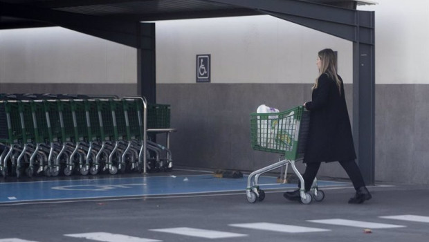 ep archivo   una mujer sale de un supermercado con un carro de la compra