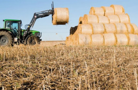 ep un tractor descargando bolas de paja