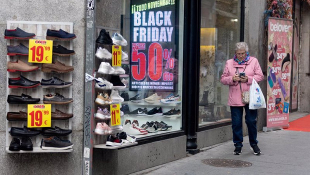 ep una mujer pasa por delante de una tienda que anuncia un cartel publicitario del black friday