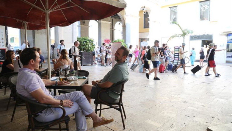 ep archivo   varias personas en una terraza mientras decenas de personas marchan desde la plaa de la